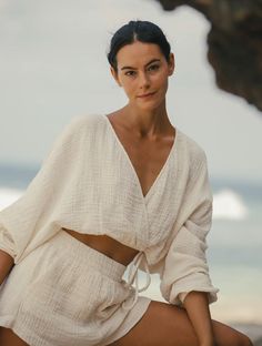 The Sienna Top's draped front design adds a touch of romance to any outfit. Made of soft, flowing material with wide sleeves, it's perfect for beach walks or layering over a transitional ensemble. Crafted from 100% Turkish cotton double gauze, this top ensures maximum comfort on warm days. Featuring a unique V-shaped front and optional hidden closure, as well as an adjustable drawstring waistband and elasticated waist, this one-size-fits-most top is a must-have addition to your wardrobe! Color: Gold Stripes Romantic Silhouette, Brunch Dates, Double Gaze, Short Waist, Double Gauze, Gold Stripes, Muslin Cotton, Wide Sleeves, Independent Designers Fashion