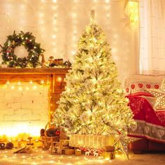 a decorated christmas tree sitting in front of a fire place with presents under the lights