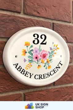 The Abbey style sign is a beautiful ceramic house sign featuring an arrangement of flowers in the centre display. This sign will bring a traditional yet contemporary look to your property or home. The house number and design are printed vinyl to give a bright, clean and visible sign for all to read. The overall thickness of the plaque is 2cm deep. All fittings and fixings are provided.

UK Sign Shop House Sign Arrangement Of Flowers, House Plaques, Quick Cleaning, Text Image, House Numbers