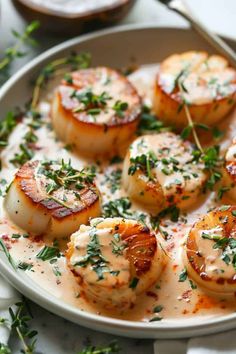 some scallops are on a plate with sauce and parsley sprinkled around them