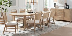 a dining room table with chairs and a potted plant