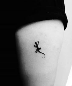 a small lizard tattoo on the right side of the thigh, it is black and white