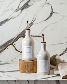 two white bottles sitting on top of a marble counter