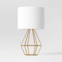 a gold lamp with a white shade on it