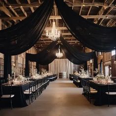 an elegant black and white wedding set up with chandelier, tablecloths, and chairs