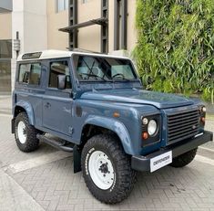 a blue land rover is parked in front of a building