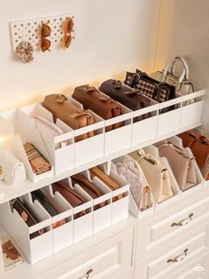 a white shelf filled with lots of purses and handbags on top of drawers