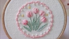 a close up of a embroidery on a piece of cloth with flowers in the center