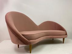 a pink couch sitting on top of a white floor