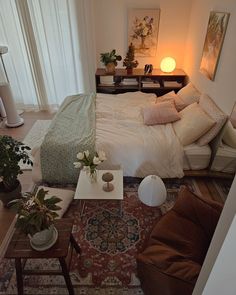 a bed sitting in the middle of a bedroom next to a table with flowers on it