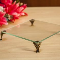 a glass table topped with a vase filled with pink flowers