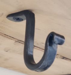 a metal hook is hanging on the side of a wooden wall