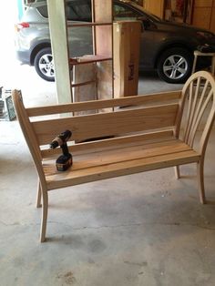 a wooden bench sitting in a garage next to a car