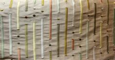 a close up of a piece of cloth with different colored pins and needles on it