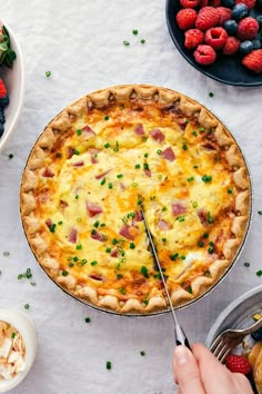 ham and cheese quiche on a table with berries