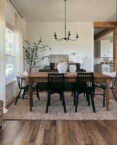 a dining room table with four chairs and a chandelier hanging from the ceiling