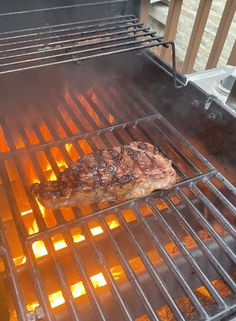 a steak is cooking on an outdoor grill