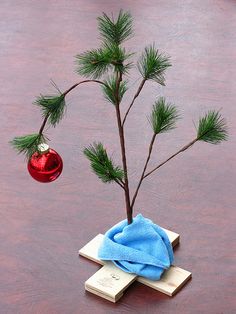 a small christmas tree with a red ornament hanging from it