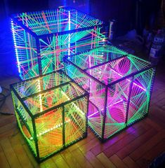 three lit cubes sitting on top of a wooden floor