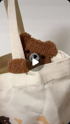 a teddy bear sticking its head out of a tote bag that is filled with fabric