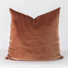 a brown velvet pillow on a white background