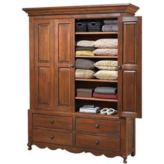 an armoire with drawers and shelves filled with folded towels, blankets and other items