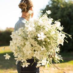 a woman holding a bouquet of white flowers