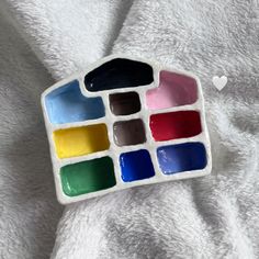 a white towel with several different colored paints in it