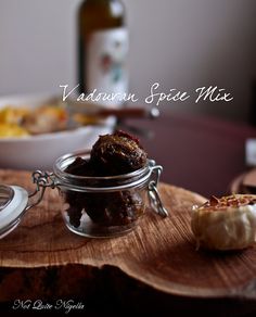 a wooden table topped with a glass jar filled with food