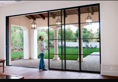 a woman standing in front of a sliding glass door with an open screen on it