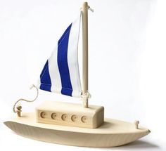 a wooden toy sailboat with blue and white stripes on it's hulls