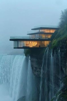 the waterfall house is lit up at night with lights on its windows and water cascading around it