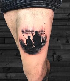 a man's leg with a black and white tattoo of two people in a boat