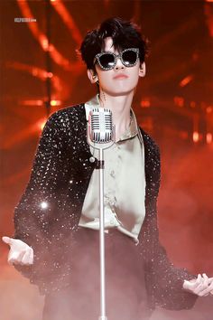 the singer is wearing sunglasses and holding a microphone