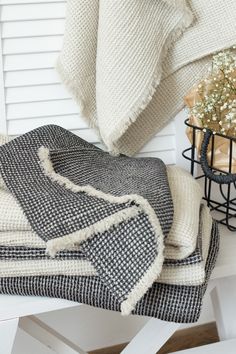 a white bench topped with blankets and flowers