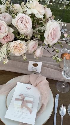 the table is set with white and pink flowers