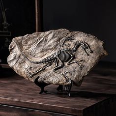 a rock with a skeleton on it sitting on top of a wooden table