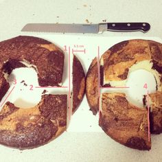 two chocolate chip donuts cut in half on top of a cutting board next to a knife