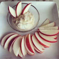 sliced apples and yogurt in a bowl on a plate