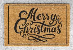 a merry christmas door mat with the words merry and handwritten in black on it