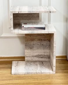 a book shelf sitting on top of a hard wood floor next to a white wall