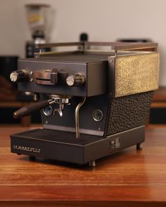 an espresso machine sitting on top of a wooden table