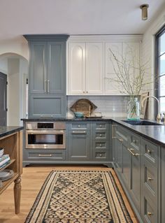 a kitchen with blue cabinets and an area rug