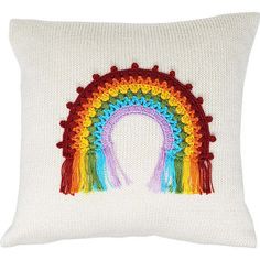 a white pillow with a rainbow design on the front and side, it is knitted in