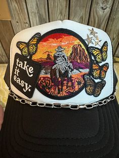 Cowboy Sunset - Take It Easy - Butterfly Trucker Hat Embroidered Patches Heat Pressed On A Trucker Hat OTTO 39-165 5 Panel High Crown Foam Front Mesh Back Polyester Foam Front 100% Polyester Front Panel With Lining Each Hat Is Hand Pressed & Are One Of A Kind Custom Made - Slight Differences Due To The Hand Made Process Butterflies Will Be Mixed/Similar Colors As Shown THESE ARE CUSTOM MADE TO ORDER - PLEASE ALLOW 7-10 DAYS TO SHIP Cowboy Trucker Hat, Trucker Hats With Patches, Trendy Trucker Hats, Cowboy Sunset, Trendy Patches, Easy Butterfly, Hat Bar, Custom Patch, Turquoise Decor