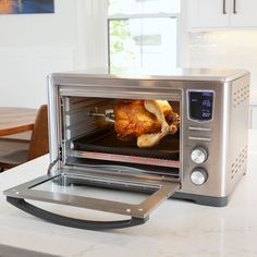 a silver toaster oven sitting on top of a kitchen counter next to a turkey