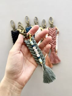 a person holding some tassels in their hand with other tassels attached to them