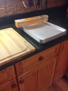 a kitchen counter topped with lots of cutting boards next to a knife and block on top of it