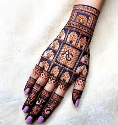 a hand with henna designs on it and purple nail polishes in the middle