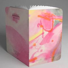 an open book with pink and yellow paint on it